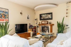 米萨诺阿德里亚蒂科Villa Le Rose - 5 minuti dal mare e Misano World Circuit的客厅配有2张白色沙发和电视