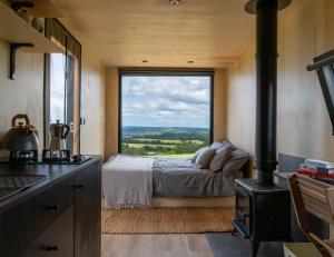 彼得斯菲尔德OffGrid Tiny Home W/ View Of South Downs NP的一间卧室设有一张床和一个大窗户