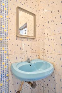 巴加Baga Beach Walk的浴室设有蓝色水槽和镜子