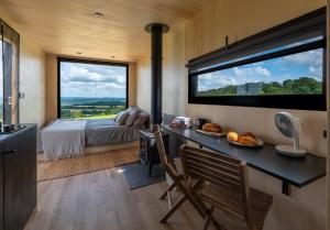 彼得斯菲尔德OffGrid Tiny Home W/ View Of South Downs NP的一间卧室配有书桌和一张带大窗户的床。