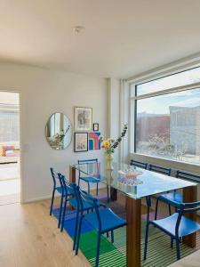 赫尔辛基New luxury 110sqm apartment with terrace and great location的一间带桌子和蓝色椅子的用餐室