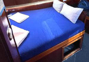 费特希耶Beforelunch Cruise的一张小床,上面有蓝色的床单和船上的枕头