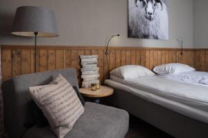 VenabygdSpidsbergseter Resort Rondane的一间卧室配有一张床、一把椅子和一盏灯