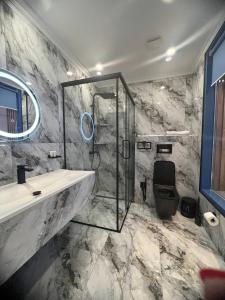 奇姆肯特Sapar Standart Улучшенный полулюкс的一间带玻璃淋浴和水槽的浴室