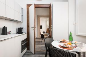 罗马Palazzo Delle Pietre - Luxury Apartments的厨房以及带桌椅的用餐室。