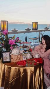 头顿Premier Pearl Hotel Vung Tau的两个女人坐在桌子上,边喝茶边花边