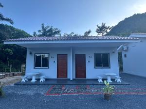 Kaki BukitGuest House Gua Kelam的前面有两长椅的小白色房子