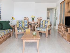 卡尔佩Apartamentos Coral Beach Unitursa的客厅配有沙发、椅子和桌子