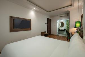 河内Eliana Premio Hotel Hanoi的卧室配有一张白色大床和电视。