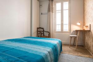 昂古莱姆Centre-ville, rempart sud的一间卧室设有蓝色的床和窗户。