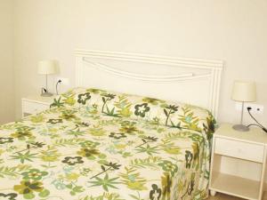 卡尔佩Apartamentos Esmeralda Suites Unitursa的一间卧室配有一张带花卉床罩的床