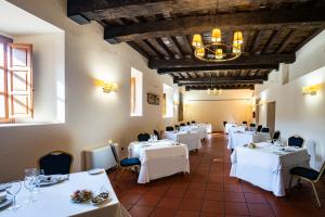 埃尔瓦安布罗兹山谷酒店的餐厅配有白色的桌椅和吊灯