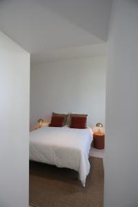 ParmainLomalia的卧室配有白色的床和两盏灯。