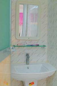 南威Raha house的浴室配有带镜子的盥洗盆和镜子