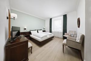 梅拉诺伊莎贝拉酒店的配有一张床和一把椅子的酒店客房