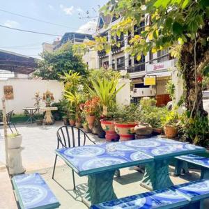 Ban NongdouangSaysouly Guest House的蓝色的桌子和椅子以及盆栽植物
