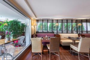 日内瓦吉卜林玛诺特酒店的餐厅设有桌椅和窗户。