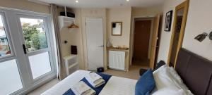 莱姆里吉斯Charnwood Guest House的一间卧室设有床、窗户和门