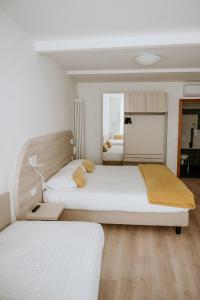 特伦托威尼斯酒店的一间卧室配有两张床和镜子