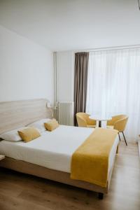特伦托威尼斯酒店的一间卧室配有一张大床和一张桌子