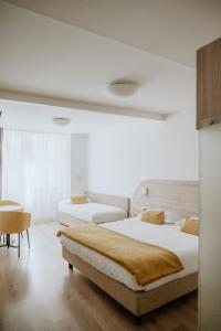 特伦托威尼斯酒店的一间卧室配有两张床和一张桌子