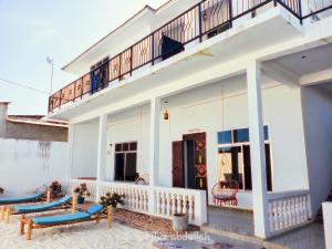 南威Raha house的带阳台和蓝色靠垫的白色房屋