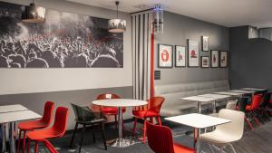 巴黎Hotel Inn Design Paris Place d’Italie (ex Timhotel)的用餐室配有桌子和红色椅子
