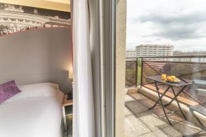 巴黎Hotel Inn Design Paris Place d’Italie (ex Timhotel)的客房设有一张床和一个美景阳台