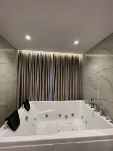 VorëReign Hotel的浴室内设有大型白色浴缸。