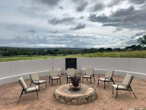 莫迪默勒7th Hole Golf Lodge的庭院里设有一组椅子和一个火坑