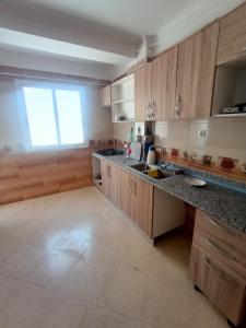 MʼSilaEL SARAYA M'SILA DZ的厨房配有木制橱柜、水槽和窗户。