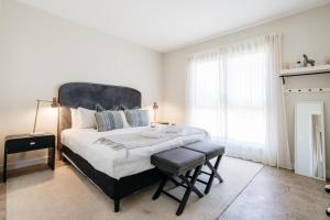 EvandaleEmbracing Evandale的白色的卧室设有一张大床和一个窗户
