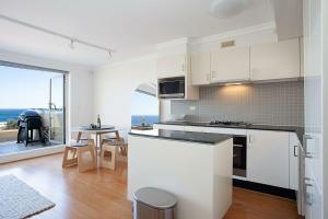 悉尼Ocean view Clovelly的一间厨房,配有白色的橱柜,享有海景