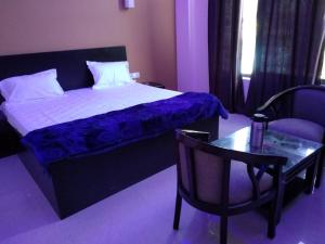 PithorāgarhHotel-78的一间卧室配有一张床、一把椅子和一张桌子