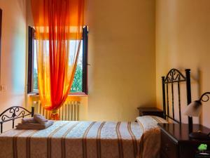 ArpinoLa Staccionata的一间卧室配有床和橙色窗帘的窗户