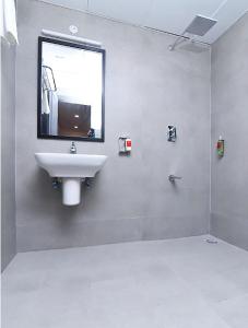 新德里Hotel Rudra的浴室设有水槽和墙上的镜子