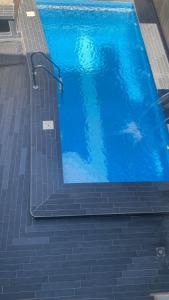 洛美Villa de Sarah的一座大型蓝色游泳池,设有楼梯