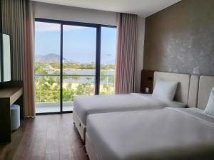 Kinh DinhGlamour Boutique的酒店客房设有两张床和大窗户。
