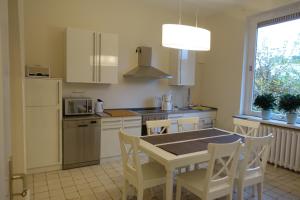 不莱梅Villa mit 5 Schlafzimmer的厨房配有桌椅和冰箱。