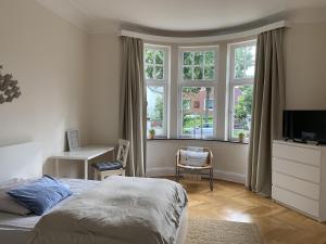 不莱梅Villa mit 5 Schlafzimmer的卧室配有一张床、一张书桌和窗户。