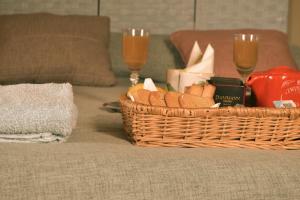 SonninoB&B SEBA e PAOLA的沙发上放着一篮面包和两杯葡萄酒