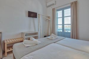 安迪帕罗斯岛曼塔乐纳酒店的一间卧室设有一张大床和一个窗户。