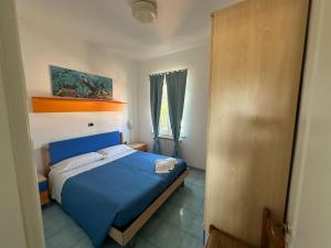 圣多米诺La Nassa的一间卧室设有蓝色的床和窗户。