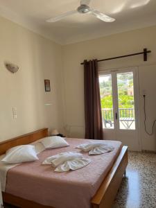 阿林达Alinda Hotel的一间卧室配有一张带白色床单的床和一扇窗户。