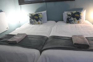 克龙斯塔德Berry Lane Guesthouse的配有2张床的带白色床单和枕头的客房