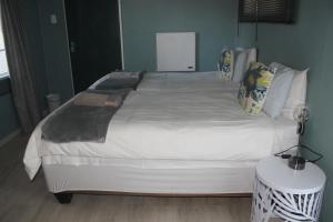 克龙斯塔德Berry Lane Guesthouse的卧室配有一张带白色床单和枕头的大床。