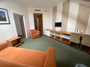 佩奇索皮阿娜精品酒店的客厅配有橙色沙发和书桌
