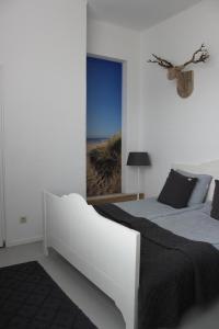 埃赫蒙德·安登胡夫Raadhuis Egmond的一间带两张床的卧室,享有海滩美景