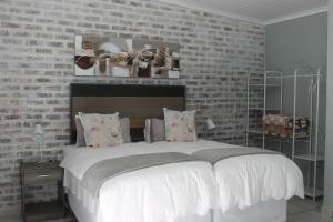 克龙斯塔德Berry Lane Guesthouse的一间卧室设有一张带砖墙的大床