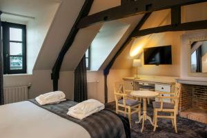 翁弗勒尔Best Western Le Cheval Blanc -Vue sur le port-plein centre ville的一间卧室配有一张床、一张桌子和一张书桌